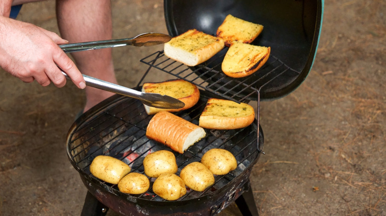 Charcoal grill with garlic bread and potatoes.