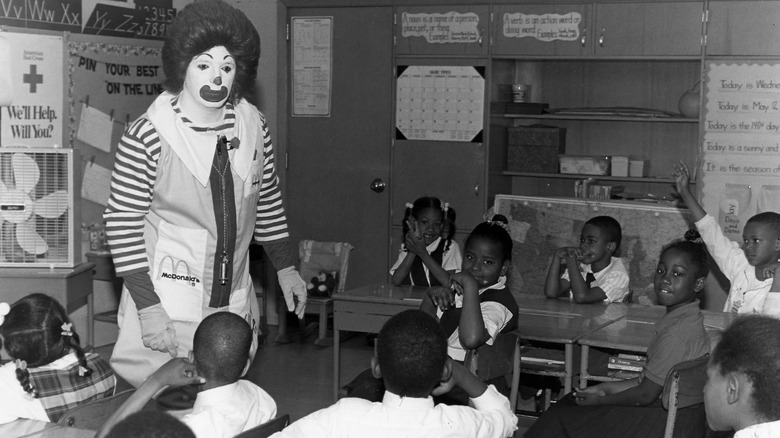 A black and white photo of Ronald McDonald in an elementary school