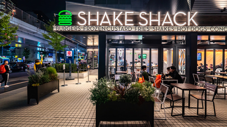 Outside a Shake Shack location with illuminated logo