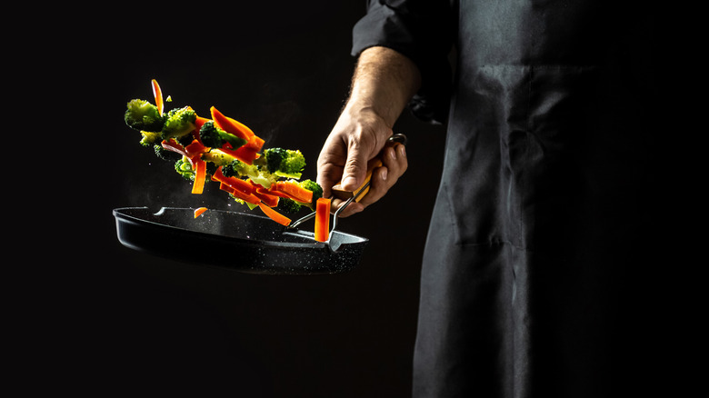 sauté pan tossing veggies