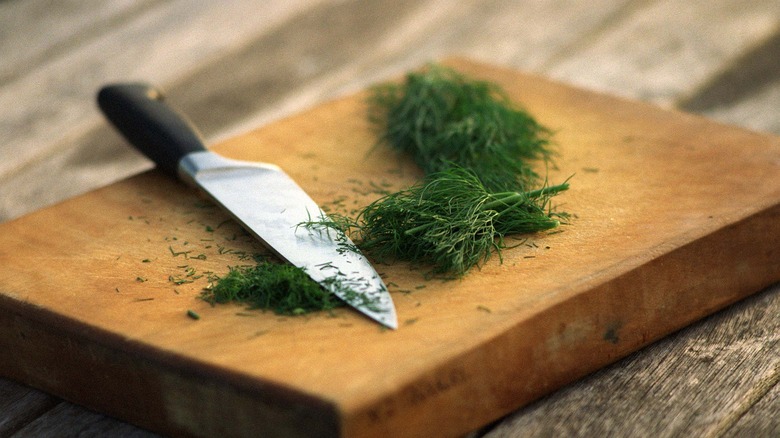 Knife and herbs on block