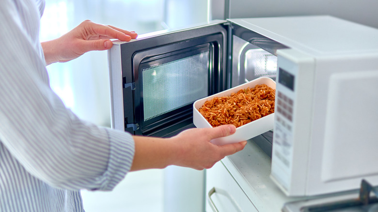 Person warming food in microwave