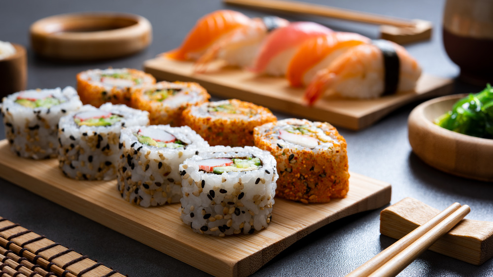 Various sushi rolls set on wooden plates