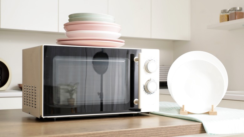 White microwave on counter with dishes