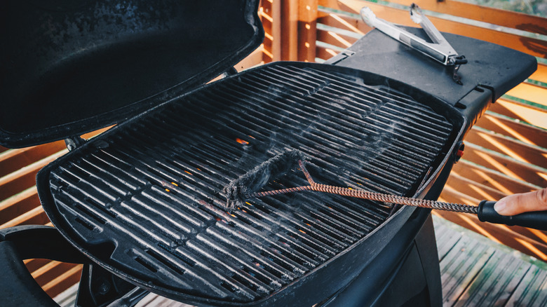 A grill brush cleans a hot grill.