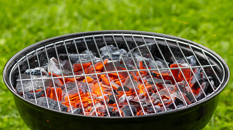 Empty grill with coals still smoldering.