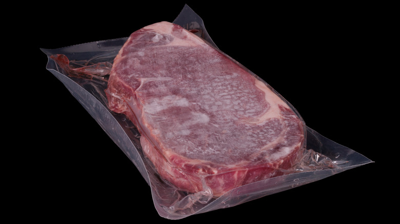 Frozen steak on black background