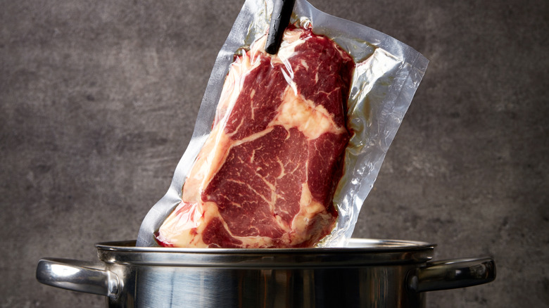 Beef in a plastic bag being placed into a pot