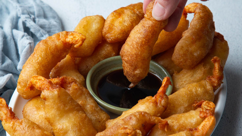 dipping shrimp tempura in sauce