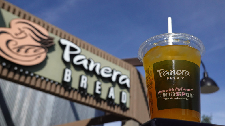 Panera beverage in front of sign 