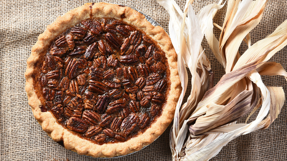 Pecan pie with corn husk on burlap background