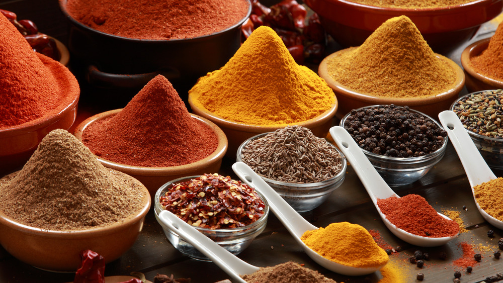 Colorful spices in bowls and on spoons