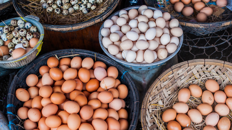 chicken and quail eggs in a basket