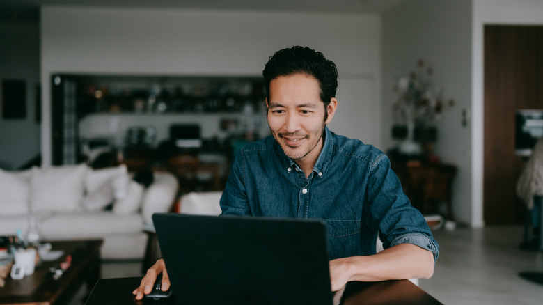 man sitting at laptop in living room