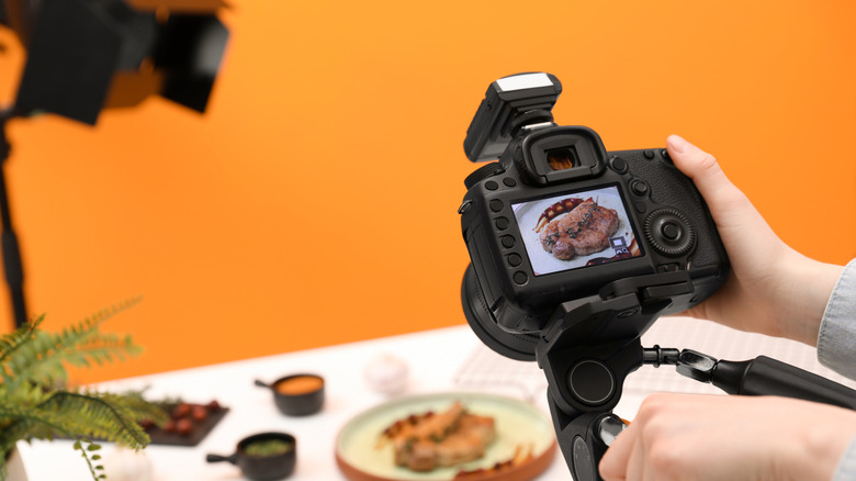 professional food photographer at work with orange background
