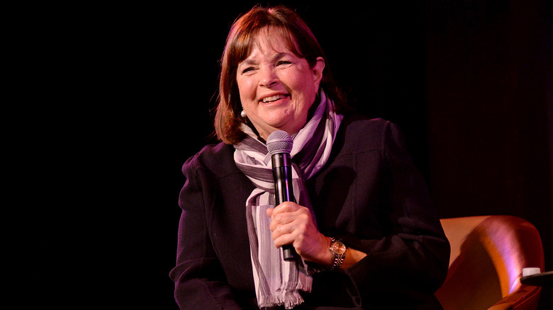 Ina Garten sits in a chair on stage, holding a microphone.