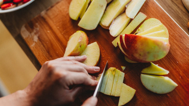 Close up of a person slicing apples
