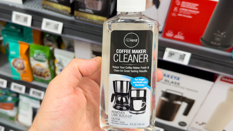 Hand holding bottle of coffee maker cleaner