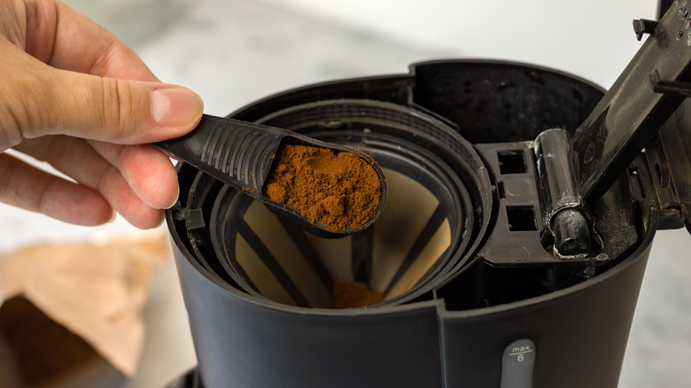 Coffee being spooned into machine
