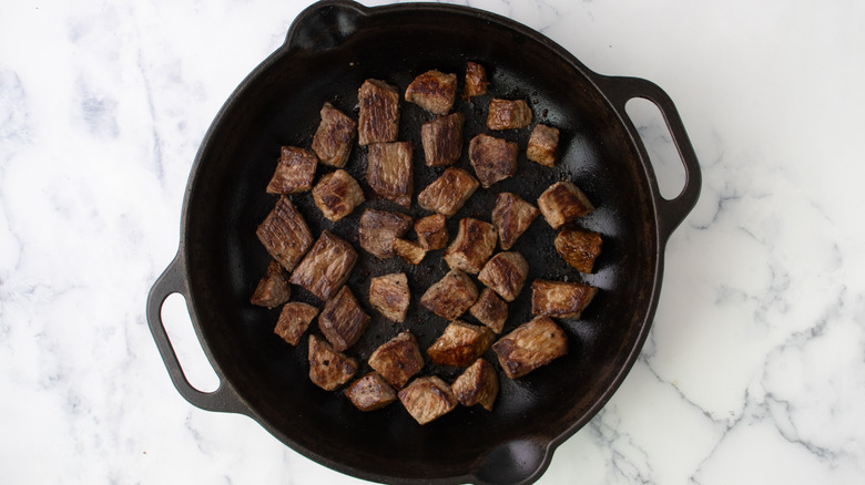 cubed steak searing in cast iron skillet