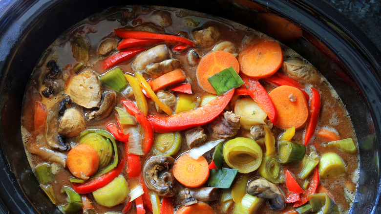 Crock-Pot filled with colorful vegetables and broth