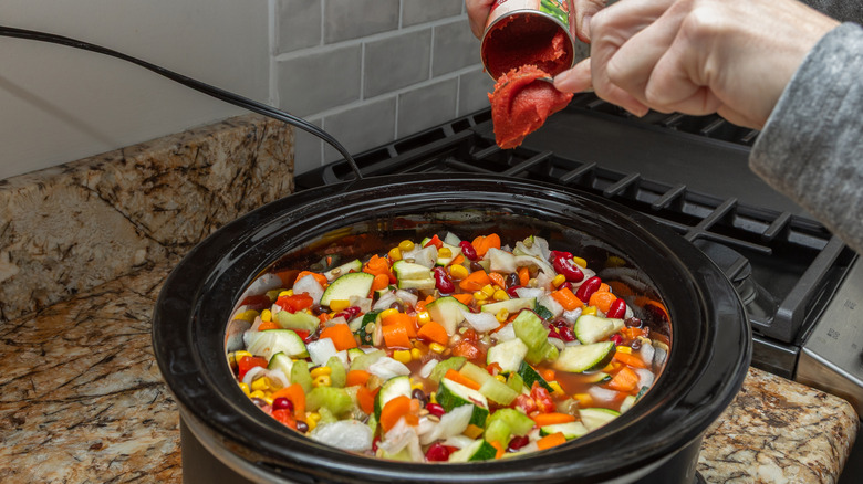A slow cooker filled with vegetable soup.