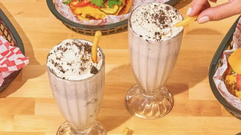 Person dipping fry into Eclipse Foods/Smashburger milkshake