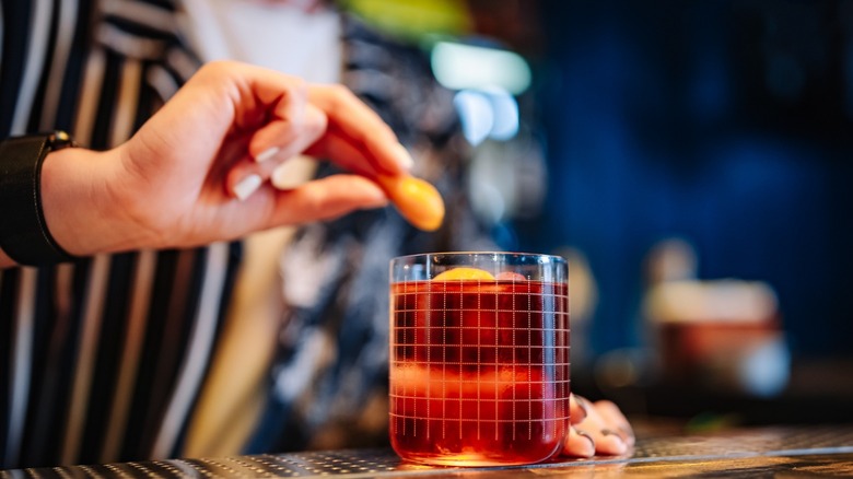 Bartender garnishing a negroni 