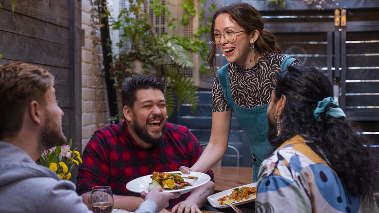 waiter laughing with customers