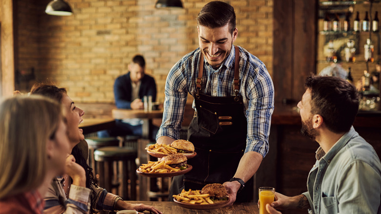 smiling waiter serving food