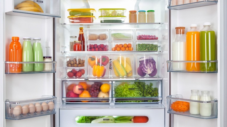 Open refrigerator fruits, vegetables, eggs, juice