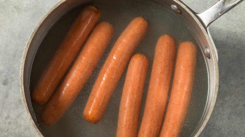 Hot dogs soaking in pan