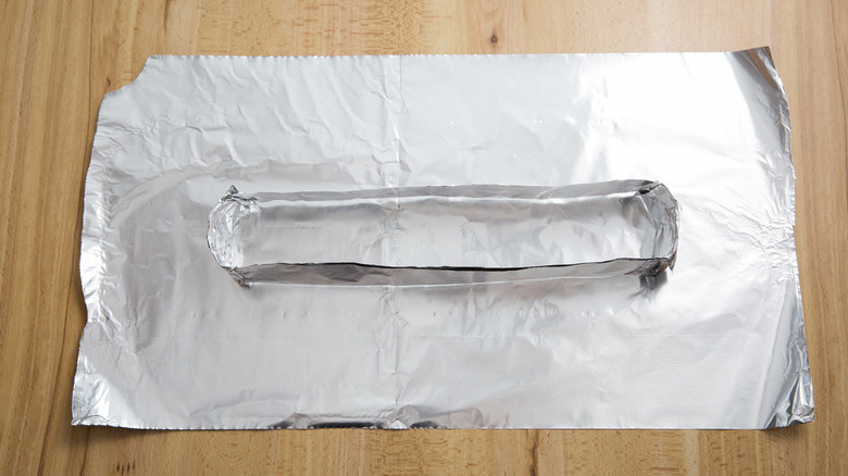big sheet of aluminum foil under a makeshift rectangular aluminum foil box on table
