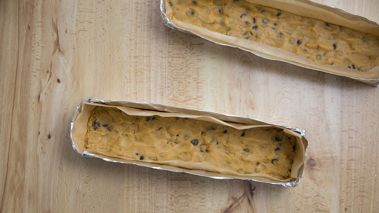 raw cookie dough for copycat Subway cookies in makeshift foil pans on wooden table