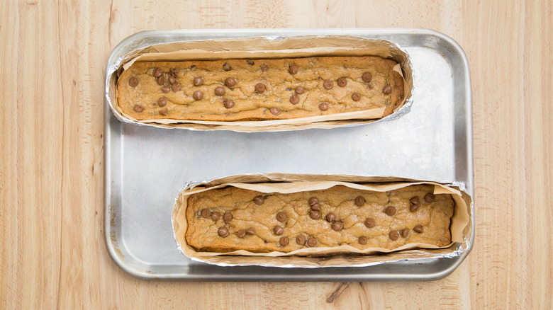 two baked copycat Subway Footlong cookies with chocolate chips on baking sheet