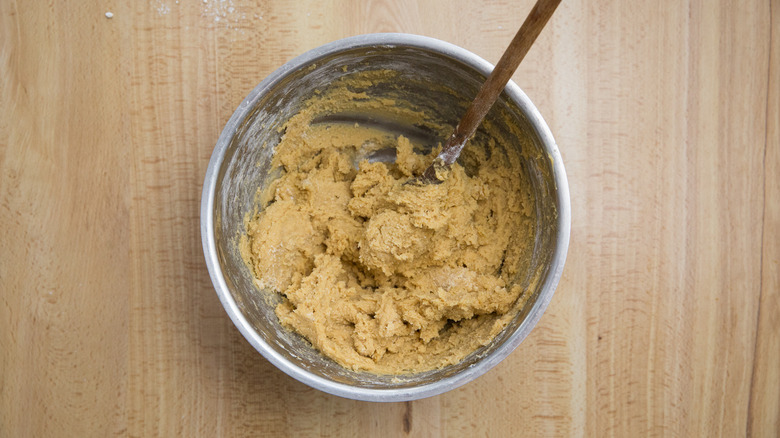 raw cookie dough in mixing bowl with a spatula