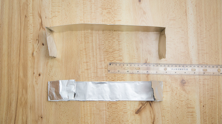 Two folded sheets of aluminum foil on table with a ruler