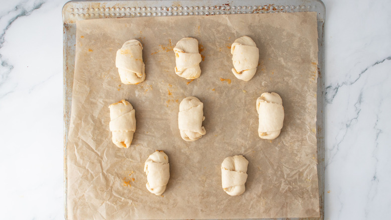 Tightly rolled crescent rolls on baking sheet