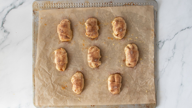 Cinnamon sugar dusted crescent rolls on baking sheet