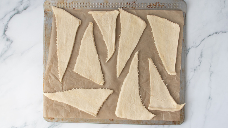 Unrolled crescent roll dough on baking sheet