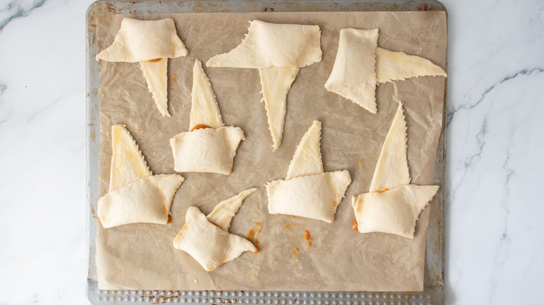 Crescent rolls halfway folded over on baking sheet