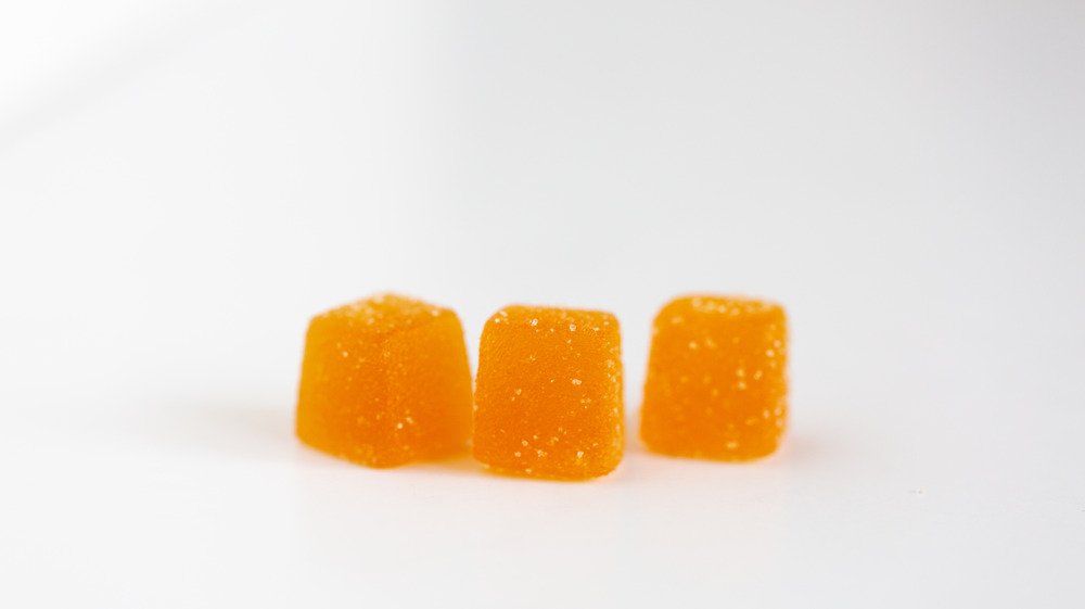 Orange gummy vitamins on background