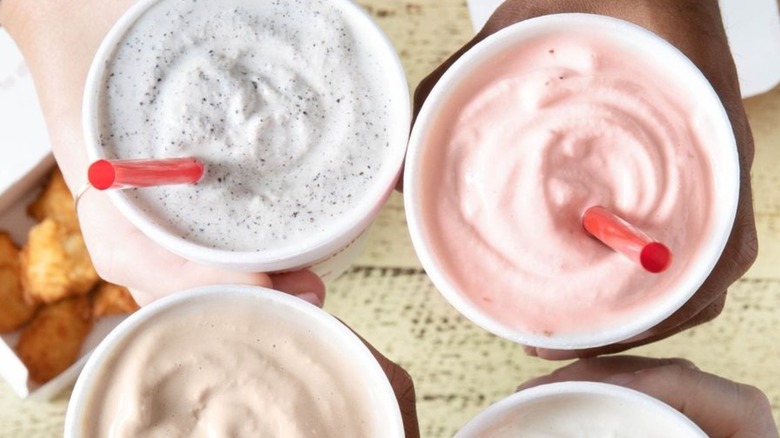 Holding different flavored Chick-fil-A milkshakes