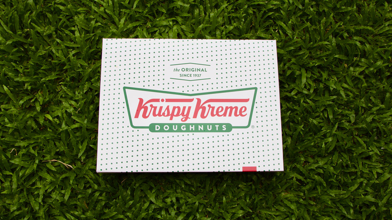 A box of Krispy Kreme donuts on grass