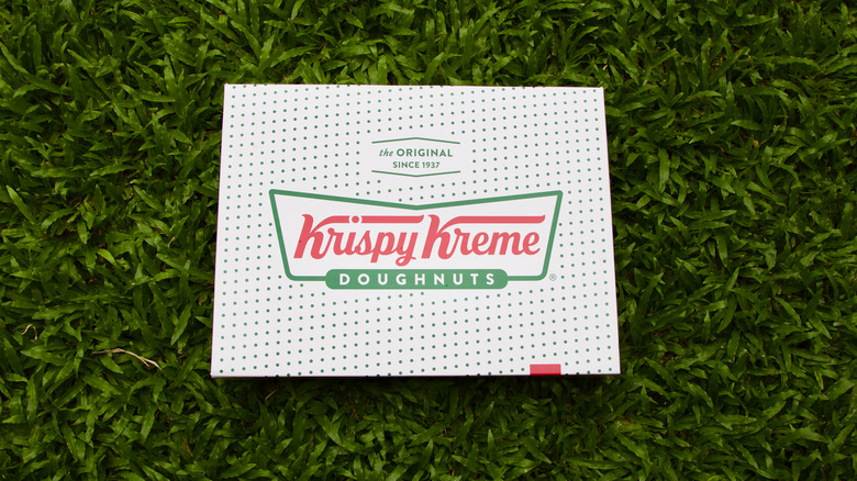 A box of Krispy Kreme donuts on grass