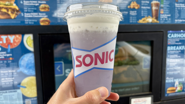 hand holding Sonic drink near drive-in menu