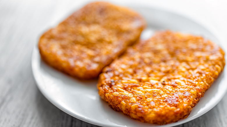 Two crispy hash browns on plate