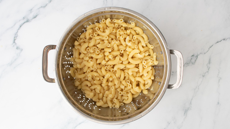 Cooked elbow noodles in colander