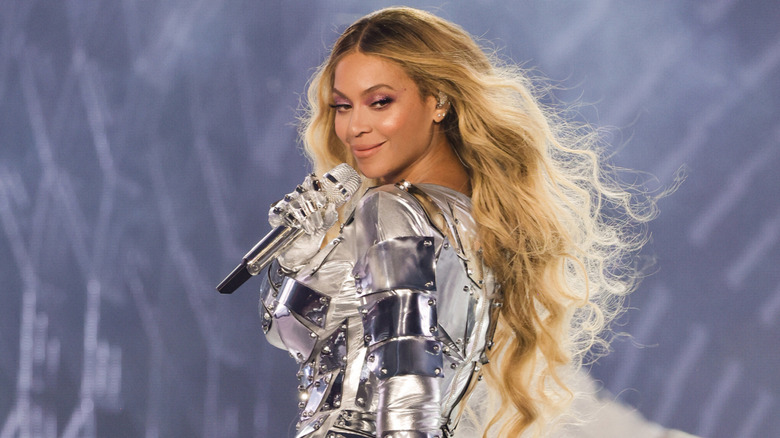 Beyoncé in in silver outfit holding a microphone