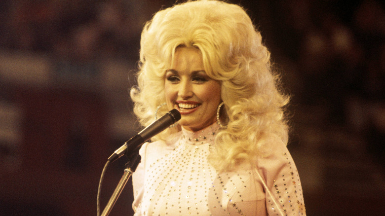 Dolly Parton smiling on stage at a concert.